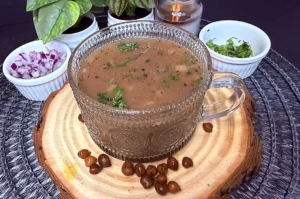 kala chana soup in a glass mug topped with chopped onion, black pepper and fresh coriander